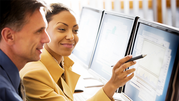 Business people reviewing analytics data on a monitor