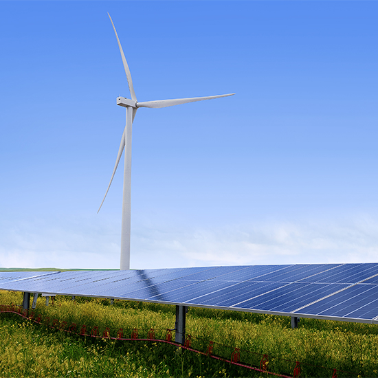 Wind energy tower behind solar panels