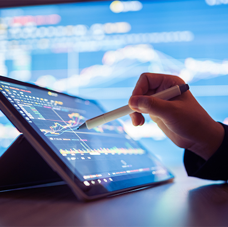 Individual reviewing analytics data using a stylus on a tablet