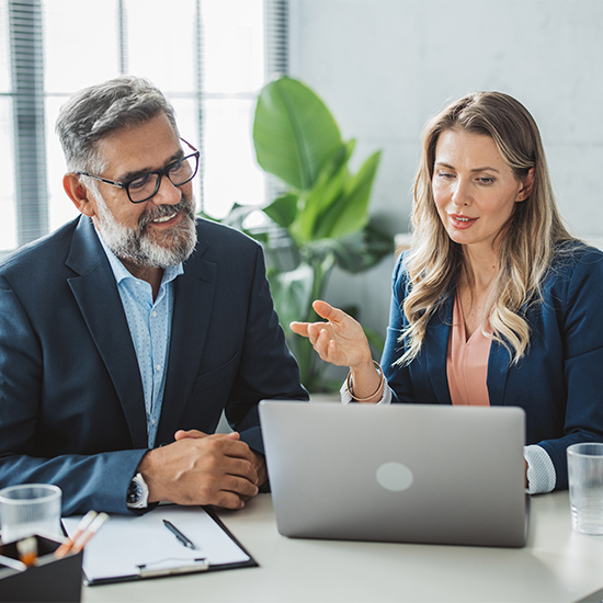 Two consultants sitting at a working on a laptop