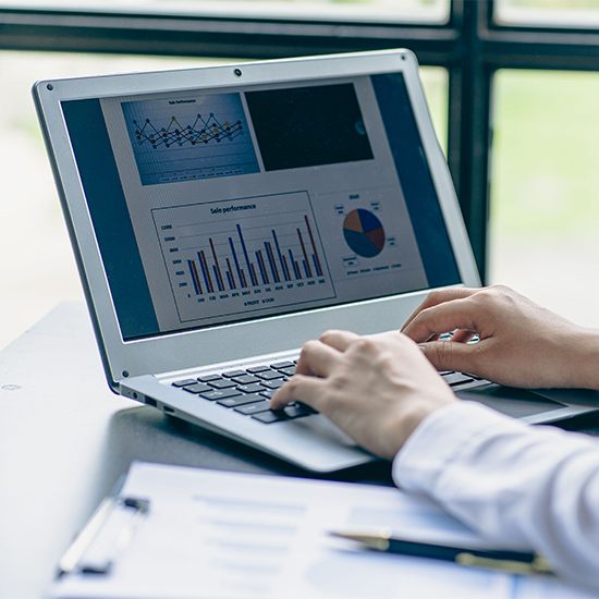 Businessman reviewing graph data on a laptop