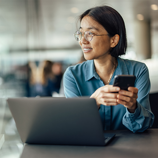 Business woman using mobile phone and laptop