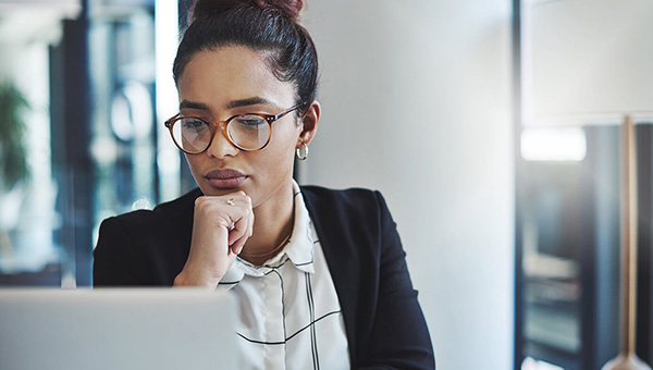 Business woman pensively looking at laptop