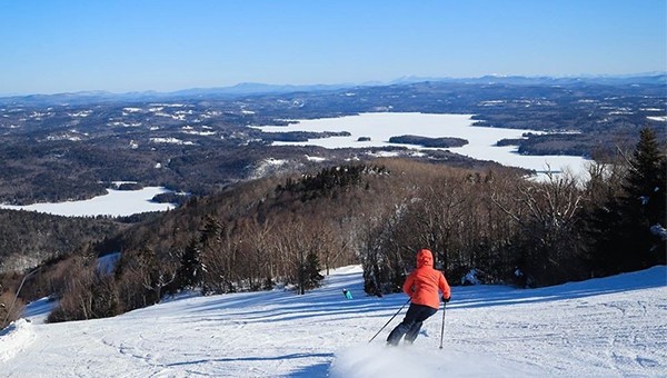 Person sking down mount Sunapee ski resort slope 