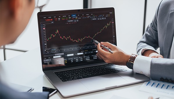 Specialists reviewing energy market on a laptop screen