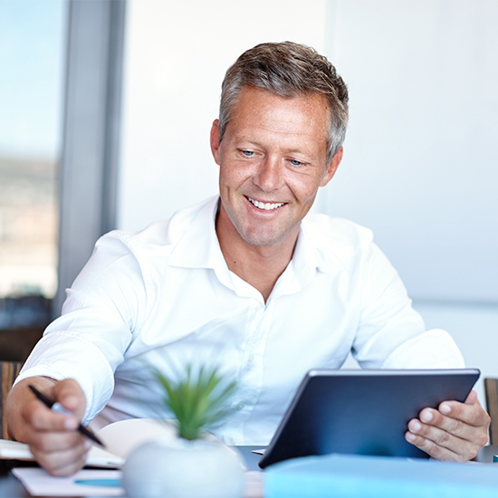 Businessman reviewing analytics data on a tablet Businessman reviewing analytics data on a tablet