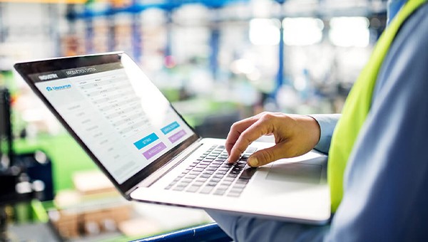 Close up of employee's hand typing on a laptop